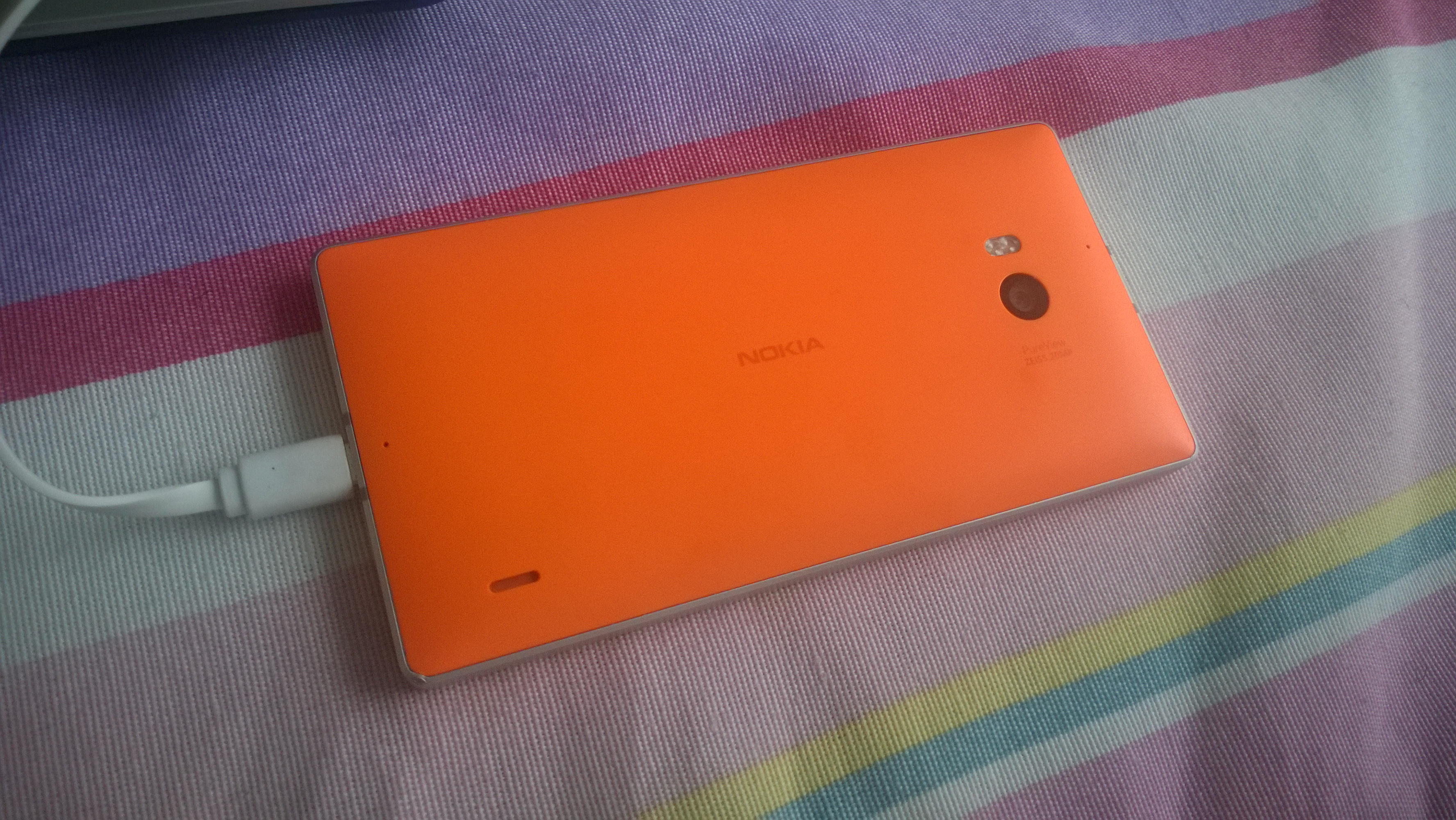 Close view of a mobile device connected to a charging cable during pre-transfer setup.