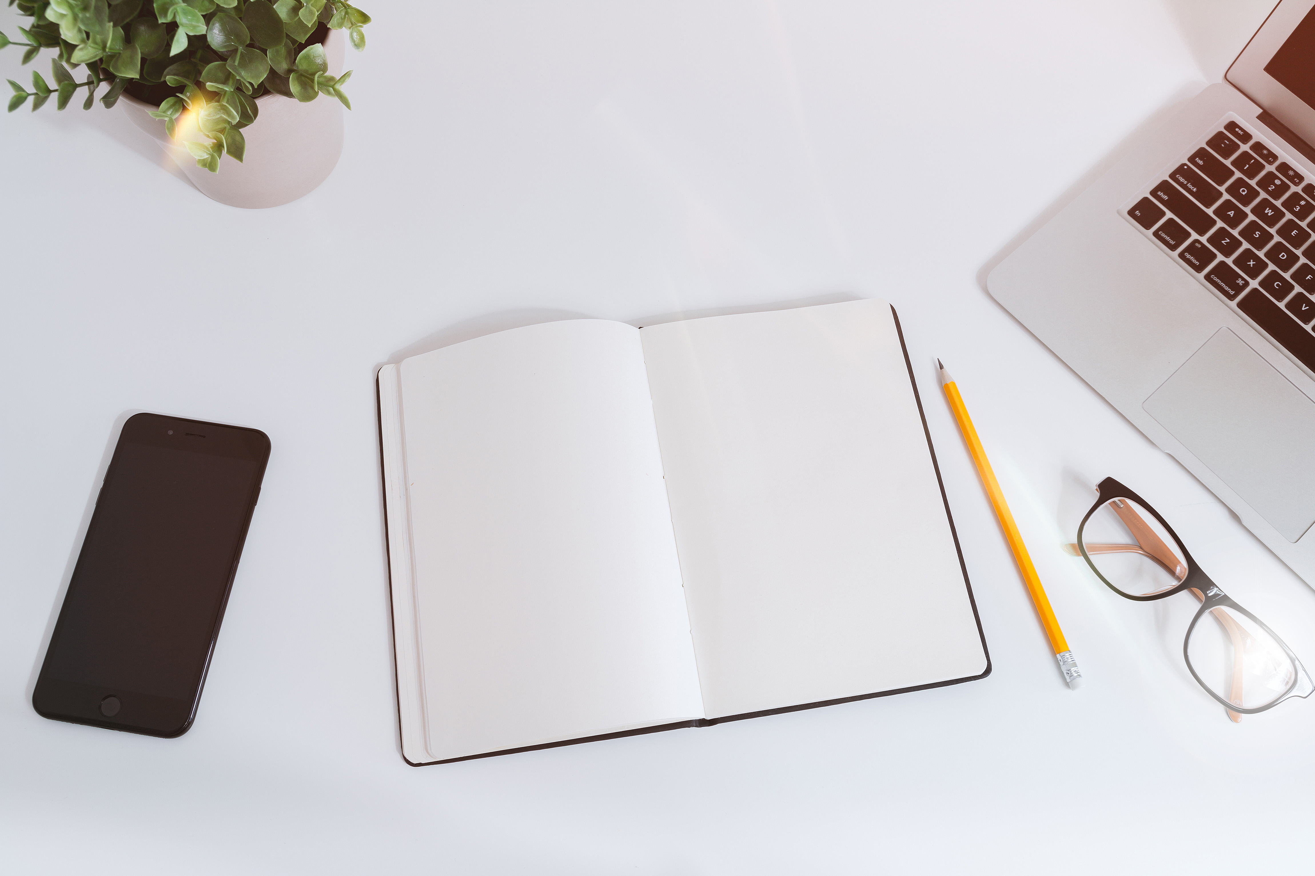 Planning a mobile transfer with a checklist notebook, phone, and laptop on a desk.